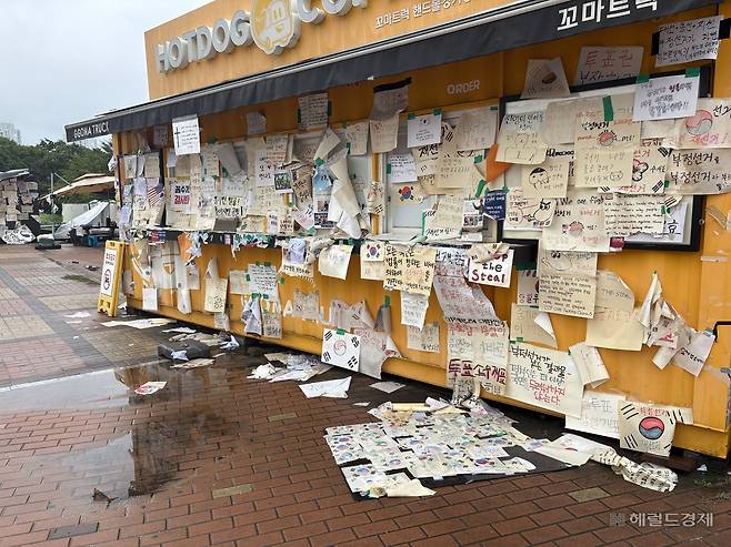 15일 오전 7시께 서울 송파구 올림픽공원 핸드볼경기장 주변. 밤사이 내린 비로 메모지들이 땅에 널브러져 있다. 윤승현 수습기자