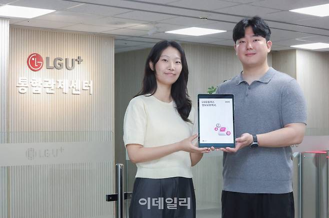 LG유플러스 정보보안센터 임직원이 ‘정보보호백서 2025’를 소개하고 있다.(사진=LG유플러스)