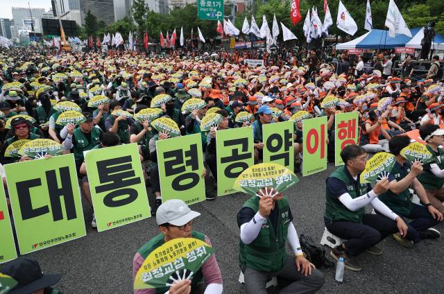 ▲전국민주노동조합총연맹(민주노총)이 7월 15일 서울 종로구 동화면세점 인근에서 연 총파업 집회에서 참가자들이 부채와 손팻말을 들고 있다. ⓒ연합뉴스