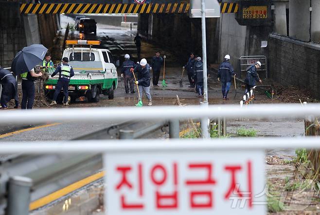 새벽부터 수도권에 집중호우가 내린 18일 서울 서대문구 증산교 인근에서 경찰과 구청 관계자들이 도로 정비를 하고 있다. 2026.7.18 ⓒ 뉴스1 김성진 기자