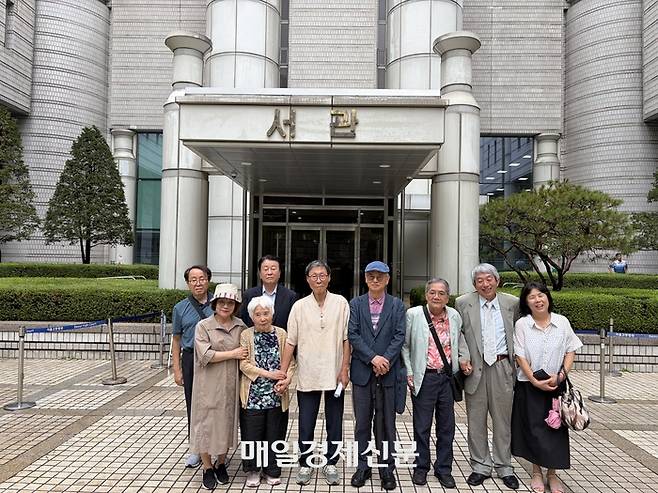 재심 무죄 선고를 받은 후 오병철 씨(왼쪽에서 다섯번째)가 배우자 등과 함께 법원 밖에 선 모습.<이승윤 기자>