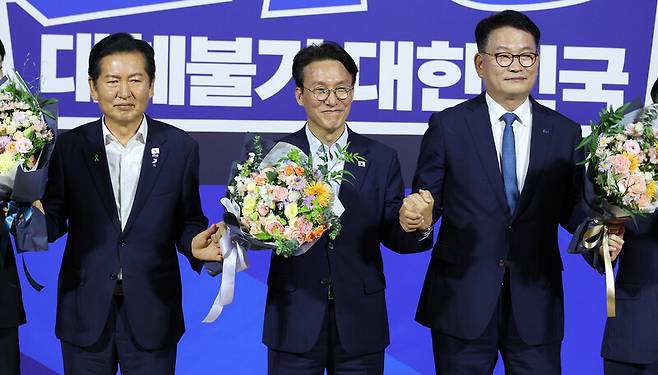 정청래(왼쪽부터)·김민석·송영길 당대표 후보가 23일 오후 국회 의원회관에서 더불어민주당 대표·최고위원 선출을 위한 8·17 전당대회 본선 진출 결과 발표 뒤 손을 잡고 있다. 김정효 기자 hyopd@hani.co.kr