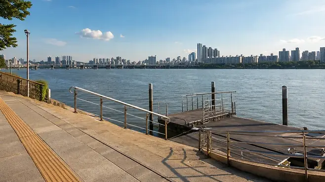뚝섬 한강공원 나들목에서 강변으로 이어지는 그늘진 보행 접근로와 포장 동선