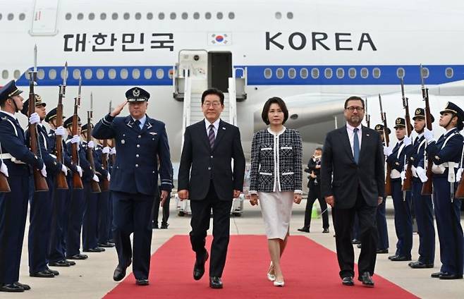 이재명 대통령과 김혜경 여사가 29일(현지시간) 칠레 산티아고 아르투로 메리노 베니테스 국제공항에 도착한 공군 1호기에서 내려 이동하고 있다. 연합뉴스