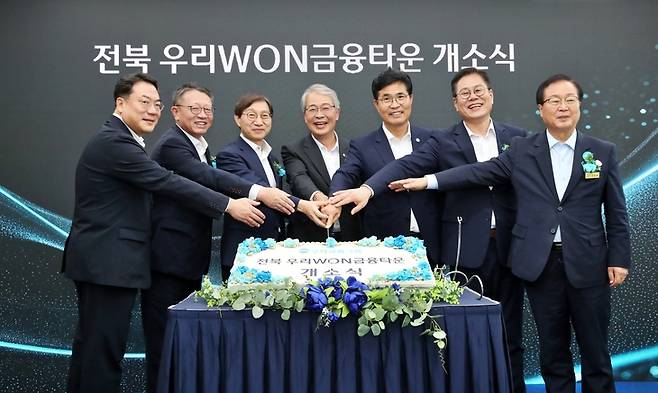 ▲지난달 29일 전북혁신도시에서 열린 '전북 우리WON금융타운' 개소식에서 (왼쪽부터)최승재 우리자산운용 대표, 정진완 우리은행장, 김성주 국민연금공단 이사장, 임종룡 우리금융그룹 회장, 이원택 전북특별자치도지사, 조지훈 전주시장, 유희태 완주군수가 개소를 기념하는 세리머니를 하고 있다.