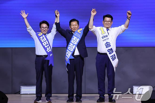 더불어민주당 당권 주자인 김민석(왼쪽부터), 정청래, 송영길 의원이 1일 대전 유성구 대전컨벤션센터에서 열린 당대표·최고위원 합동연설회에서 손을 맞잡고 당원들에게 인사하고 있다. 2026.8.1 ⓒ 뉴스1 신웅수 기자