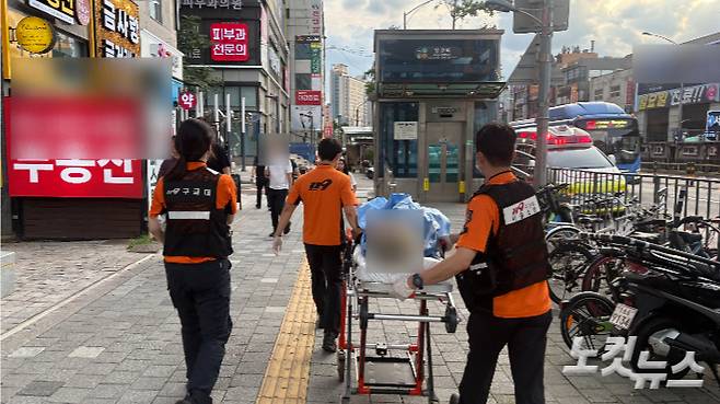지난달 25일 오후 6시 30분쯤 대원들이 무연고 노숙인 환자를 들것에 태워 구급차로 옮기고 있다. 김수정 기자