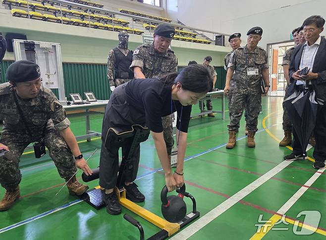 7일 육군 제1보급단 스마트 물류센터 야외전시장에서 기자가 직접 웨어러블 로봇을 입고 20kg 케틀벨을 들어올리고 있다. ⓒ 뉴스1 김예원 기자