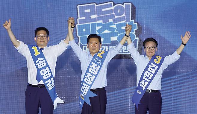 송영길, 정청래, 김민석(왼쪽부터) 당대표 후보가 8월2일 부산 벡스코에서 열린 더불어민주당 대표·최고위원 순회 경선 합동연설회에서 손을 맞잡아 올리고 있다. ⓒ연합뉴스