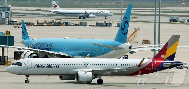 지난 5월 인천국제공항 제2터미널 계류장에서 아시아나항공(앞)과 대한항공(뒤) 여객기가 이동하는 모습(자료사진). 2026.5.18 ⓒ 뉴스1 김진환 기자