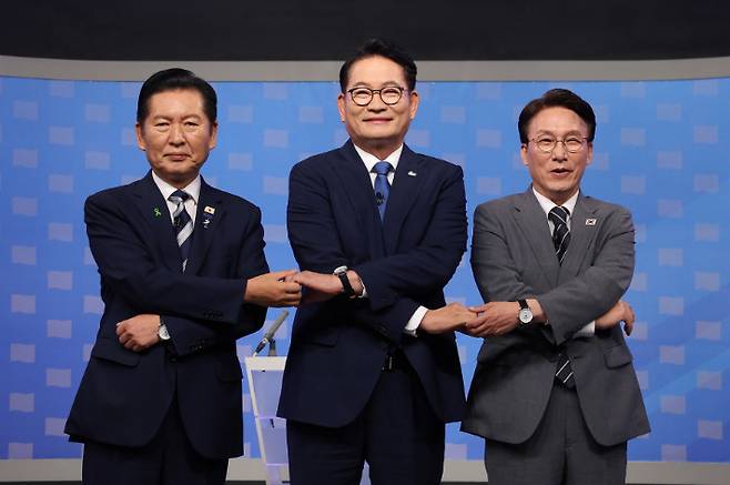 더불어민주당 정청래(왼쪽부터)·송영길·김민석 당 대표 후보가 12일 서울 양천구 SBS 목동 스튜디오에서 열린 TV 토론회에 참석해 손을 잡고 기념 촬영하고 있다. 연합뉴스