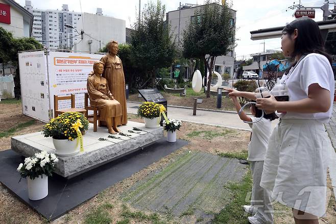 제81주년 광복절을 하루 앞둔 14일 전남광주 남구 양림동 근대역사문화마을에서 딸이랑 같이 온 시민이 남구 평화의 소녀상을 보고 있다. 2026.8.14 ⓒ 뉴스1 조수민 기자