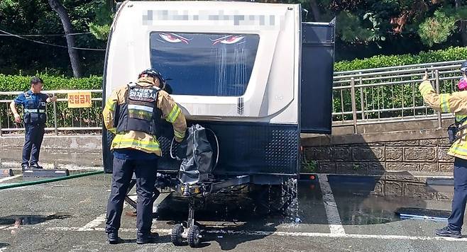 19일 오전 부산 서구 암남공원 공영주차장에 주차된 캠핑 카라반에서 불이 나 소방이 불을 끄는 모습 (소방 제공)