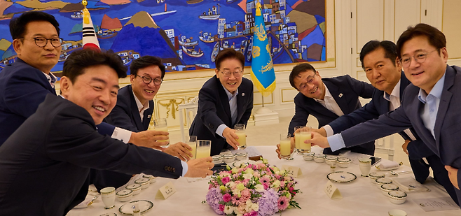 이재명 대통령이 19일 청와대에서 열린 더불어민주당 당대표·후보자 만찬 간담회에서 김민석 대표, 정청래 전 대표, 송영길 의원 등 참석자들과 생과일주스로 건배하며 웃고 있다. (청와대)