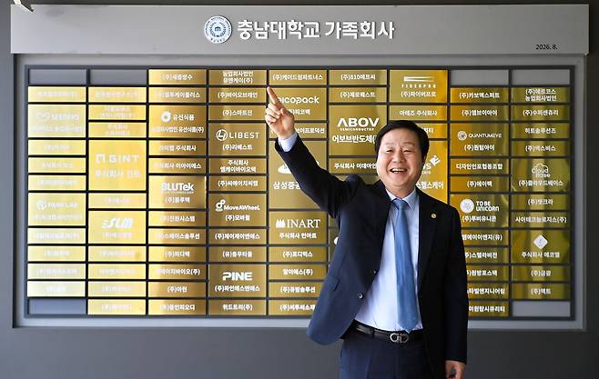 김정겸 충남대 총장이 18일 오후 대전 유성구 충남대 산학협력관 앞에서 산학협력 협약을 맺은 기업들의 명패를 배경으로 한 손을 들어 포즈를 취하고 있다. 김성태 객원기자