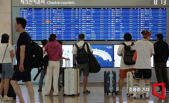 인천국제공항 제1여객터미널 출국장에서 해외여행을 떠나는 이들이 비행스케줄을 확인하고 있다. 조용준 기자
