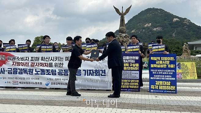 예금보험공사 및 금융감독원 노동조합이 24일 청와대 사랑채 앞에서 지방이전 저지 공동 대응 기자회견에서 김상우 금융감독원 노조위원장(왼쪽)이 의견서를 대통령실 경청통합수석실에 전달하고 있다.(사진=연희진 기자 toyo@)