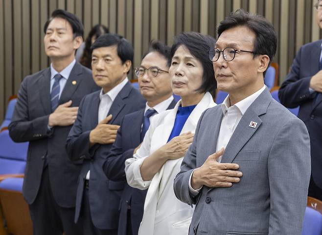 ▲더불어민주당 김민석 대표(오른쪽 첫 번째)와 최고위원들이 20일 국회에서 전당대회 뒤 처음으로 열린 의원 총회에서 국기에 경례하고 있다. 사진=연합뉴스