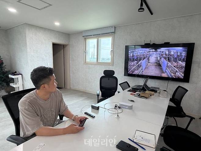 박경원 호은농장 대표가 휴대폰을 통해 농장 내부를 보여주고 있는 모습. ⓒ데일리안 김소희 기자