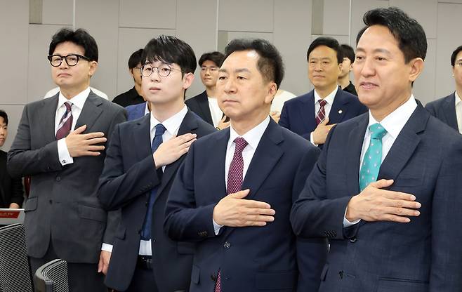 오세훈 서울시장과 무소속 한동훈 의원 등이 25일 국회 의원회관에서 열린 제10차 대한민국 미래혁신포럼 세미나 “미국의 대전략과 한국의 선택”에서 국기에 경례하고 있다. 연합뉴스.
