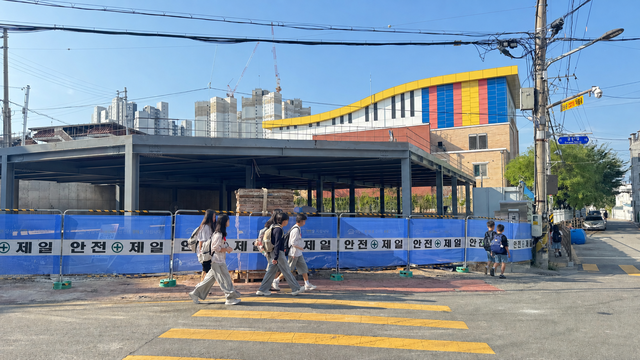 26일 오전 전주시 덕진구 금암초등학교 인근 공영주차장 공사 현장 앞을 학생들이 지나고 있지만, 통행을 안내하는 안전요원이나 신호수는 보이지 않고 있다. /이상구 기자