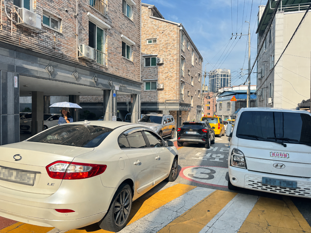 26일 오전 전주시 덕진구 금암초등학교 인근 좁은 통행로에서 차량들이 학생들이 등하교 때 이용하는 도로 가장자리 보행 공간까지 침범하고 있다. /이상구 기자