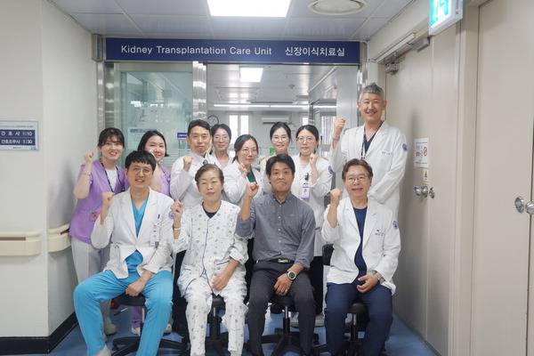 지난 11일 부산 봉생기념병원에서 신장이식 수술을 받은 엄마(앞줄 왼쪽 두 번째)와 아들(앞줄 왼쪽 세 번째)이 퇴원을 앞두고 신장이식팀과 함께 기념촬영을 하고 있다. 봉생기념병원 제공