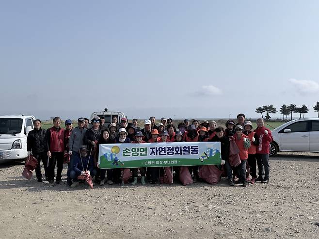 손양면 이장·부녀회장들이 남대천 자연정화활동을 하고 있다.
