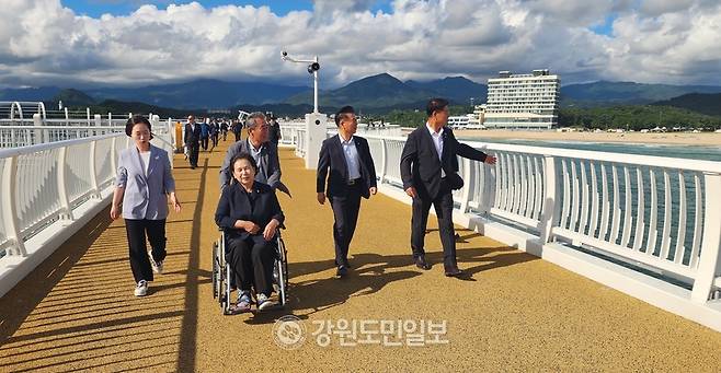 ▲ 함영빈 고성군의회 의장이 진혜련 고성군의원의 휠체어를 밀어주고 있는 가운데 함명준 고성군수와 이양수 국회의원이 바다하늘길을 거닐며 완성도 높은 사계절 체류형 글로벌 관광플랫폼 연계 시너지 극대화를 논의하고 있다.