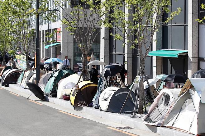 지난 7일 대구 달서구 '상인푸르지오 센터파크' 분양사무소 앞에서 선착순 전세 계약 접수를 기다리는 사람들이 우산, 텐트, 캠핑용 의자 등으로 자리를 맡은 채 장사진을 이루고 있다. 뉴스1