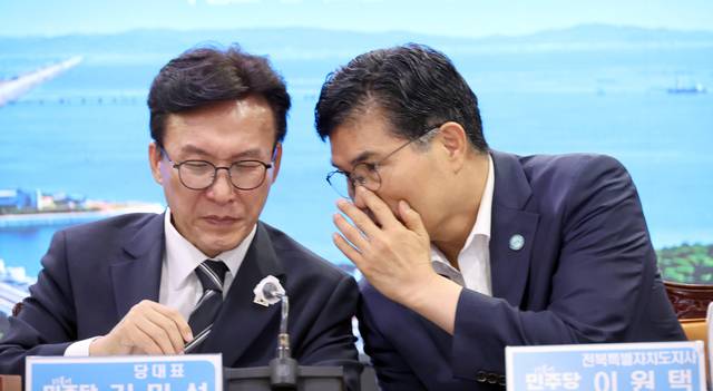 김민석(왼쪽) 더불어민주당 대표가 9일 전북도청에서 열린 현장 최고위원회의에서 이원택 전북지사와 귓속말을 나누고 있다. 연합뉴스