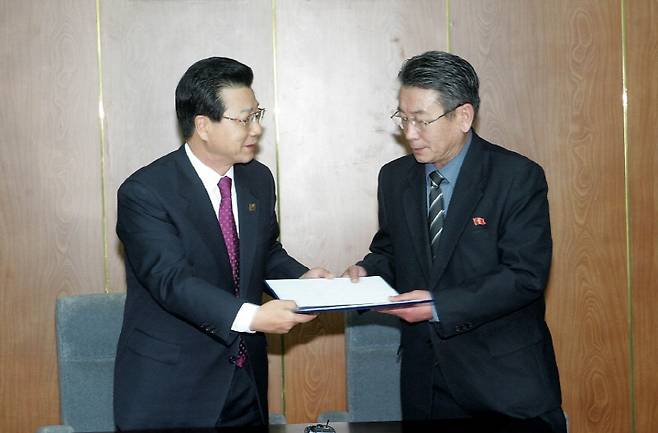 김진선 지사가 평양 방문에서 북한 문재덕 조선체육지도위원장(오른쪽)과 북측의 2014평창동계올림픽 유치 지지 등이 담긴 합의문을 교환하고 있다.