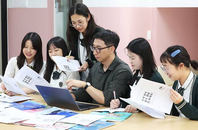 지난 7일 경기 수원 영복여고에서 교사와 학생들이 수시 모집 요강을 살펴보고 있다. 연합뉴스