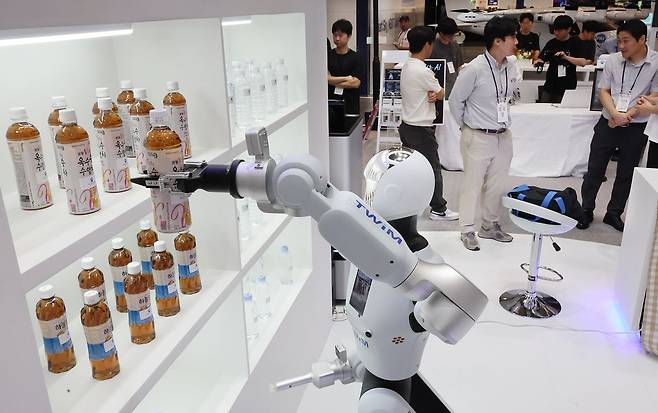 부산 해운대구 벡스코 제1전시장에서 열린 '2026 월드 스마트시티 엑스포' 스마트시티부산 부스에서 AI 휴머노이드 서비스 로봇이 참가자들에게 줄 물을 집고 있다. 연합뉴스