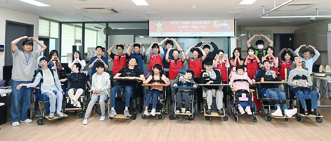 LG전자 '라이프스굿 봉사단' 인원들이 추석을 앞둔 지난 15일 염리장애인주간보호센터를 찾아 이용 장애인들이 함께 단체 사진을 찍고 있다. (사진=LG전자)