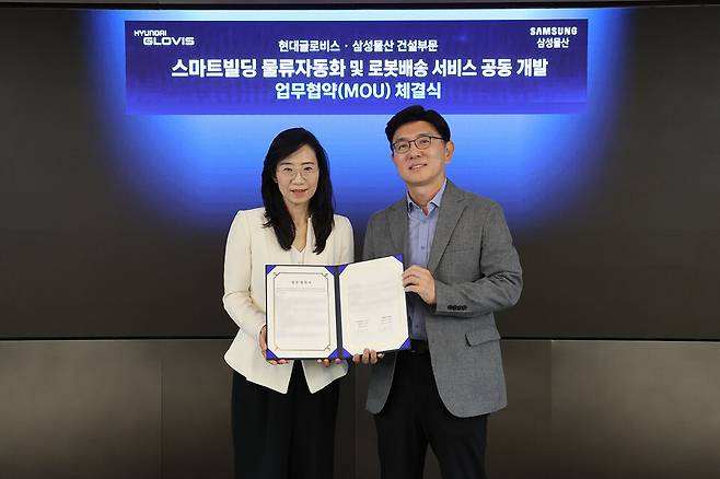 한규헌 현대글로비스 미래혁신기술센터장(오른쪽)과 조혜정 삼성물산 DxP본부장이 지난 16일 현대글로비스 본사에서 '스마트빌딩 물류자동화 및 로봇배송 서비스 공동 개발과 관련한 업무협약'을 체결한 후 기념 촬영을 하고 있다./현대글로비스
