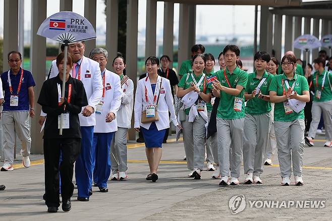 재일조선인 자원봉사자들 환영받으며 입장하는 북한 관계자들 (나고야=연합뉴스) 서대연 기자 = 2026 아이치·나고야 아시안게임 개막 하루 전인 18일 일본 나고야항 선수단 숙소 인근 광장에서 열린 웰컴 세리머니에서 북한 박천종 선수단장, 고철호 조선올림픽위원회 서기장을 비롯한 관계자들이 입장하며 재일조선인 자원봉사자들의 환영을 받고 있다. 2026.9.18 dwise@yna.co.kr
