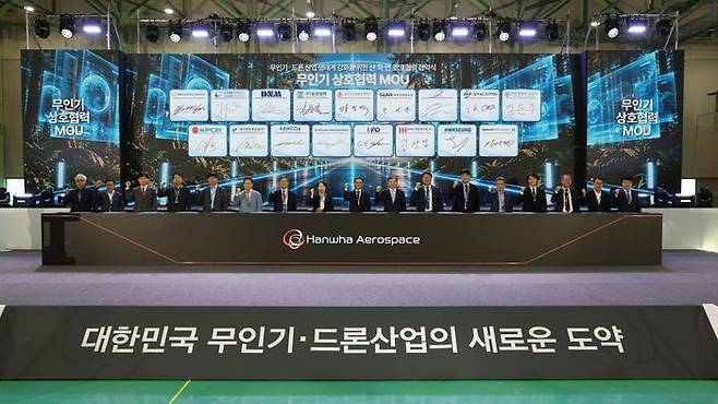21일 경남 창원특례시 한화에어로스페이스 창원1사업장에서 진행된 '산∙학∙연 상호협력 협약식'에서 국내 무인기·드론 업계 관계자들이 기념사진을 찍고 있다. ⓒ한화에어로스페이스