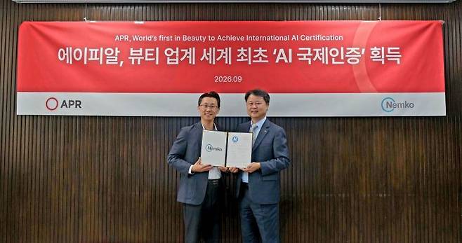 신재우 에이피알 연구개발(R&D)센터장(왼쪽)이 에이피알이 AI 제품 신뢰성 마크인 AI Trust Mark 인증을 획득하여 곽삼근 넴코 코리아 전무와 함께 기념촬영을 하고 있다. 에이피알 제공