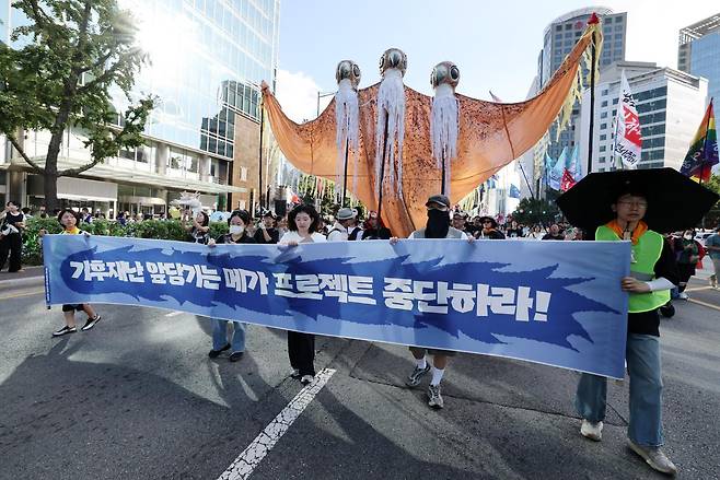9·19 기후정의행진 참석자들이 19일 서울 중구 태평로에서 '기후재난 앞당기는 메가프로젝트 중단하라!'라고 적힌 현수막을 들고 광화문 방향으로 행진하고 있다. 뉴스1