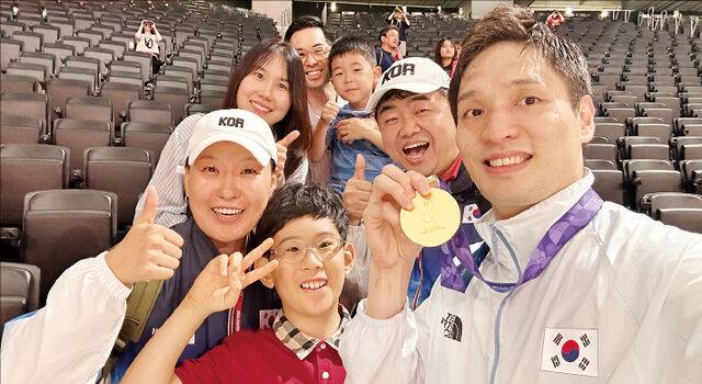 대한민국 남자농구대표팀 장재석(오른쪽) 선수가 지난 20일 일본 나고야에서 열린 2026 아이치·나고야 아시안게임 남자농구 결승전 승리 후 한국올림픽선교회 사무총장 황승택(오른쪽 두 번째) 목사, 응원단과 기념촬영을 하고 있다. 한국올림픽선교회 제공