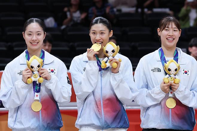 대한민국 이해란(가운데)이 26일 일본 나고야 아이치 인터내셔널 아레나에서 열린 2026 아이치·나고야 아시안게임 여자농구 시상식에서 금메달을 깨물고 있다. 뉴스1