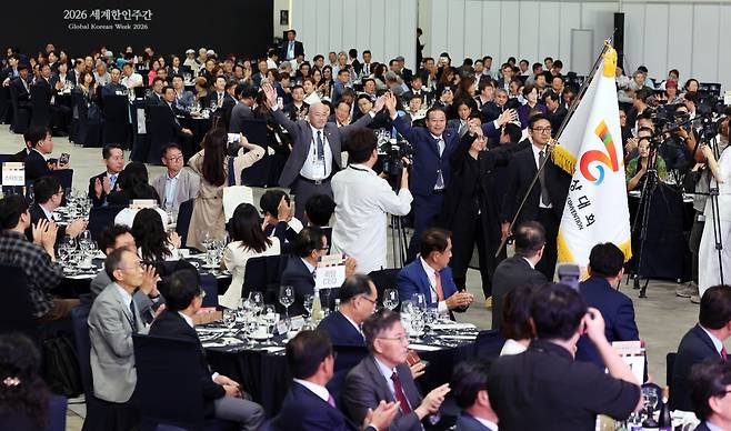 29일 인천 연수구 송도컨벤시아에서 열린 '2026 제24차 세계한상대회'에 참석한 하경서 세계한상대회 대회장이 한상기와 함께 입장하고 있다./김경민 기자 time20406@incheonilbo.com