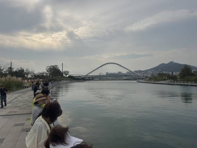 29일 오전 부산 북항 친수공원을 찾은 시민들이 수로를 따라 길게 늘어선 채 이날 외해 유도를 앞둔 상어