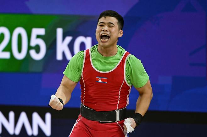 북한 로광렬이 28일 일본 나고야시 중소기업진흥회관에서 열린 2026 아이치·나고야 아시안게임 역도 남자 85㎏급 용상 3차 시기에서 214㎏을 성공시킨 뒤 포효하고 있다. 로광렬은 이 시기로 용상 214㎏, 합계 379㎏의 세계신기록을 세우며 금메달을 확정했다. 나고야=하상윤 기자