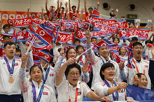 북한 선수단과 재일본조선인총연합회(조총련) 응원단이 28일 일본 나고야시 중소기업진흥회관에서 열린 2026 아이치·나고야 아시안게임 역도 남자 85㎏급 경기가 끝난 뒤 함께 응원 구호를 외치고 있다. 이날 경기장에는 조총련 응원단 100여 명이 찾아와 금메달을 딴 로광렬을 응원했다. 나고야=하상윤 기자