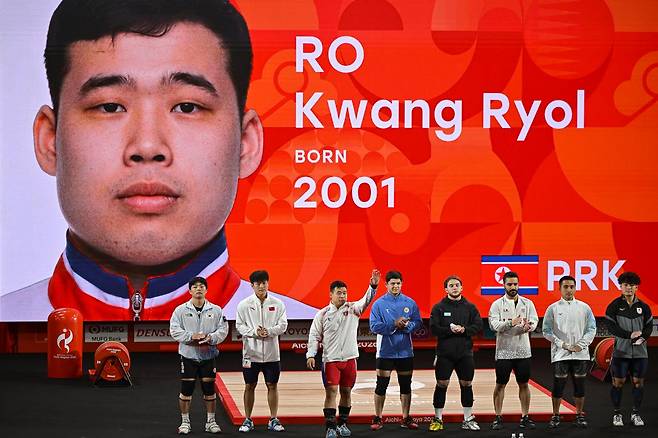 북한 로광렬이 28일 일본 나고야시 중소기업진흥회관에서 열린 2026 아이치·나고야 아시안게임 역도 남자 85㎏급 경기에 앞서 선수 소개 때 인사하고 있다. 로광렬은 이날 용상 214㎏, 합계 379㎏의 세계신기록으로 금메달을 차지했다. 나고야=하상윤 기자