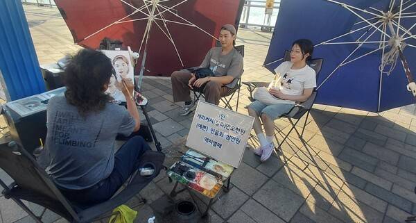 송준일 작가가 작업실인 월미도 문화의 거리에서 시민들의 인물화를 그리고 있다.
