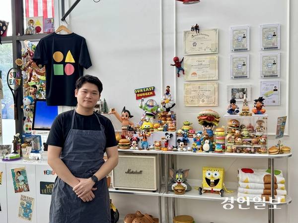 마정혁 셰프가 햄버거를 든 캐릭터 피규어와 조리 자격증이 진열된 매장 한쪽에 서 있다. 피규어는 군 전역 무렵부터 조금씩 모은 것이다. 2026.9.29 여주/양동민기자 coa007@kyeongin.com