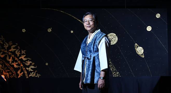김 장인이 캔버스에 금박을 입힌 대표작 ‘금빛 궤도’ 앞에 서 있다.